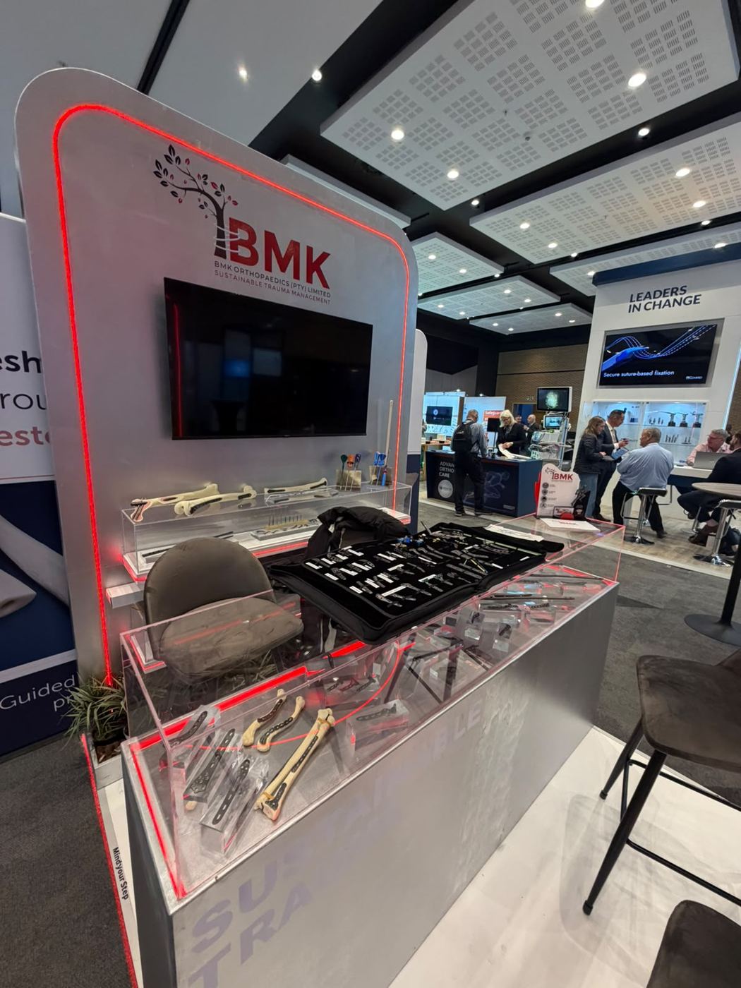 Custom exhibition stand built for BMK Orthopaedics, with an illuminated instrument display counter showcasing orthopaedic implants and surgical tools