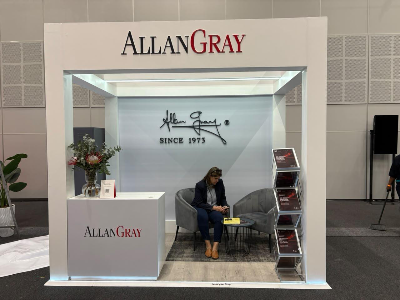 Custom exhibition stand built for Allan Gray, front-on view showing the 'Since 1973' signature wall and lounge seating
