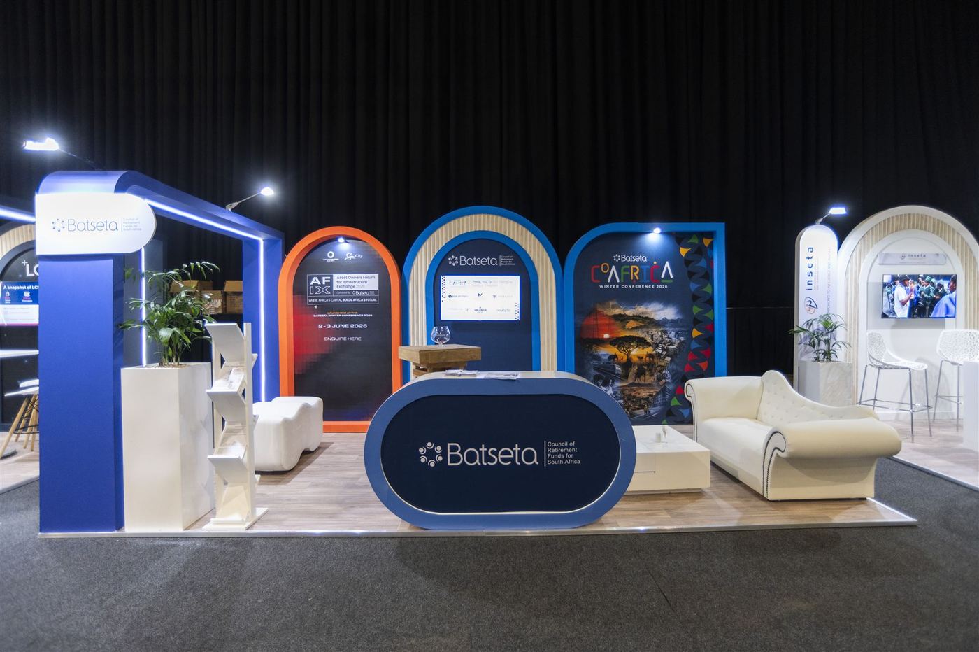 Custom exhibition stand built for Batseta, Council of Retirement Funds for South Africa, with branded arches and a reception counter
