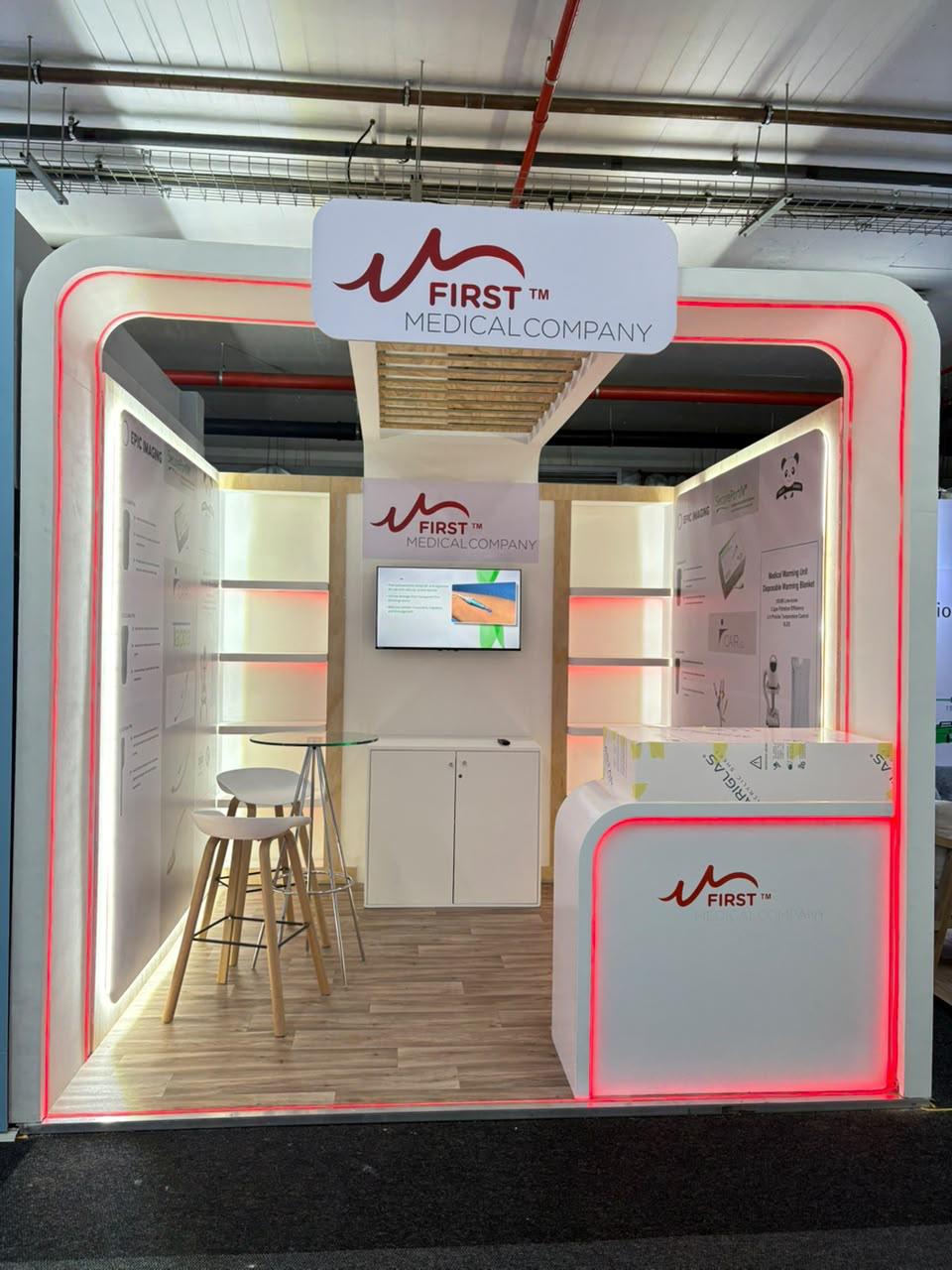 Custom exhibition stand built for First Medical Company, with illuminated red trim and bar seating