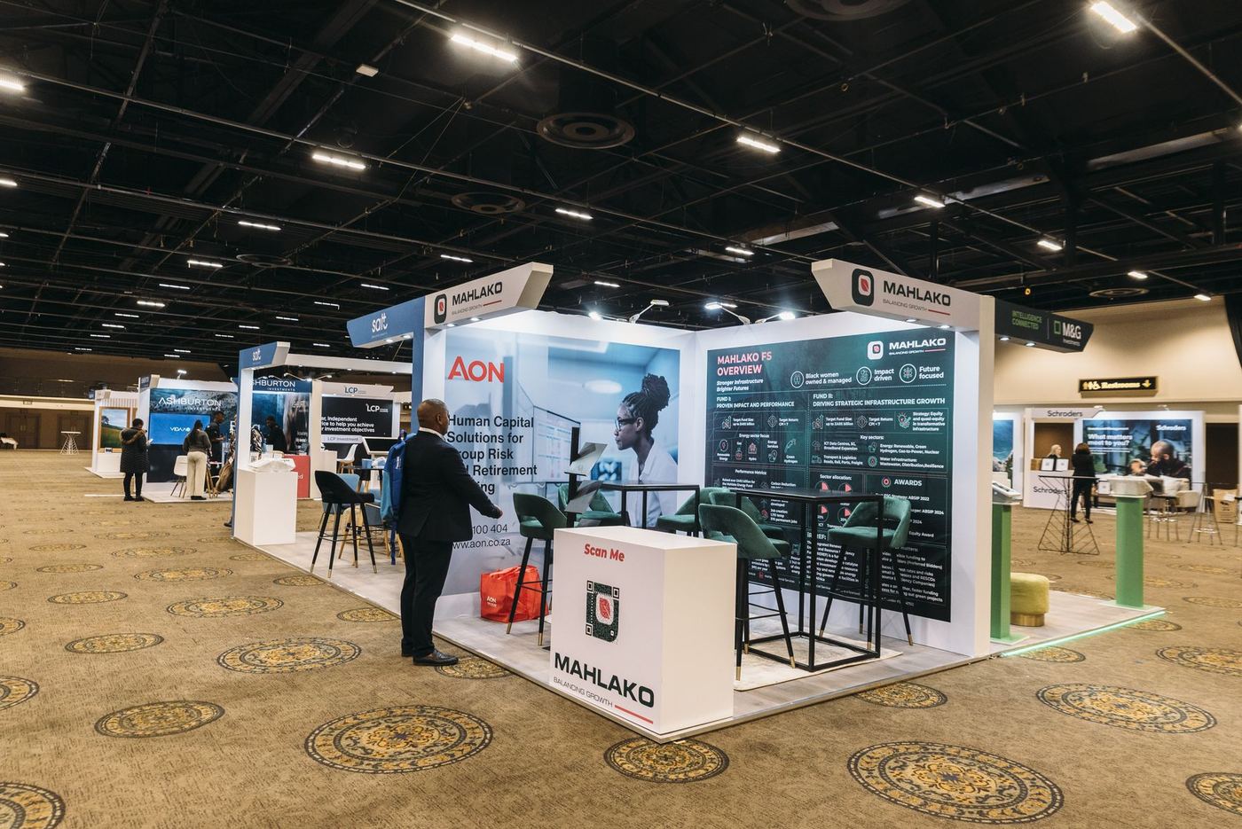 Custom exhibition stand built for Mahlako, with branded overhead signage and a meeting lounge